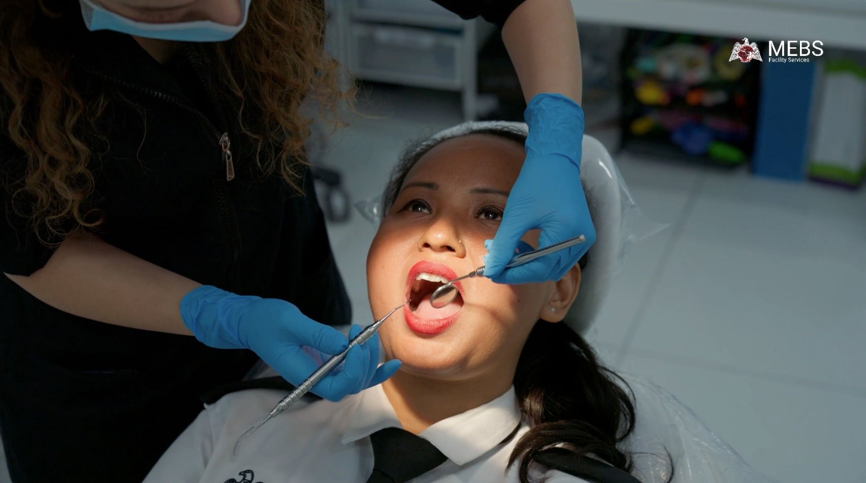Staff receiving dental hygiene guidance at MEBS Facility Services corporate CSR health camp
