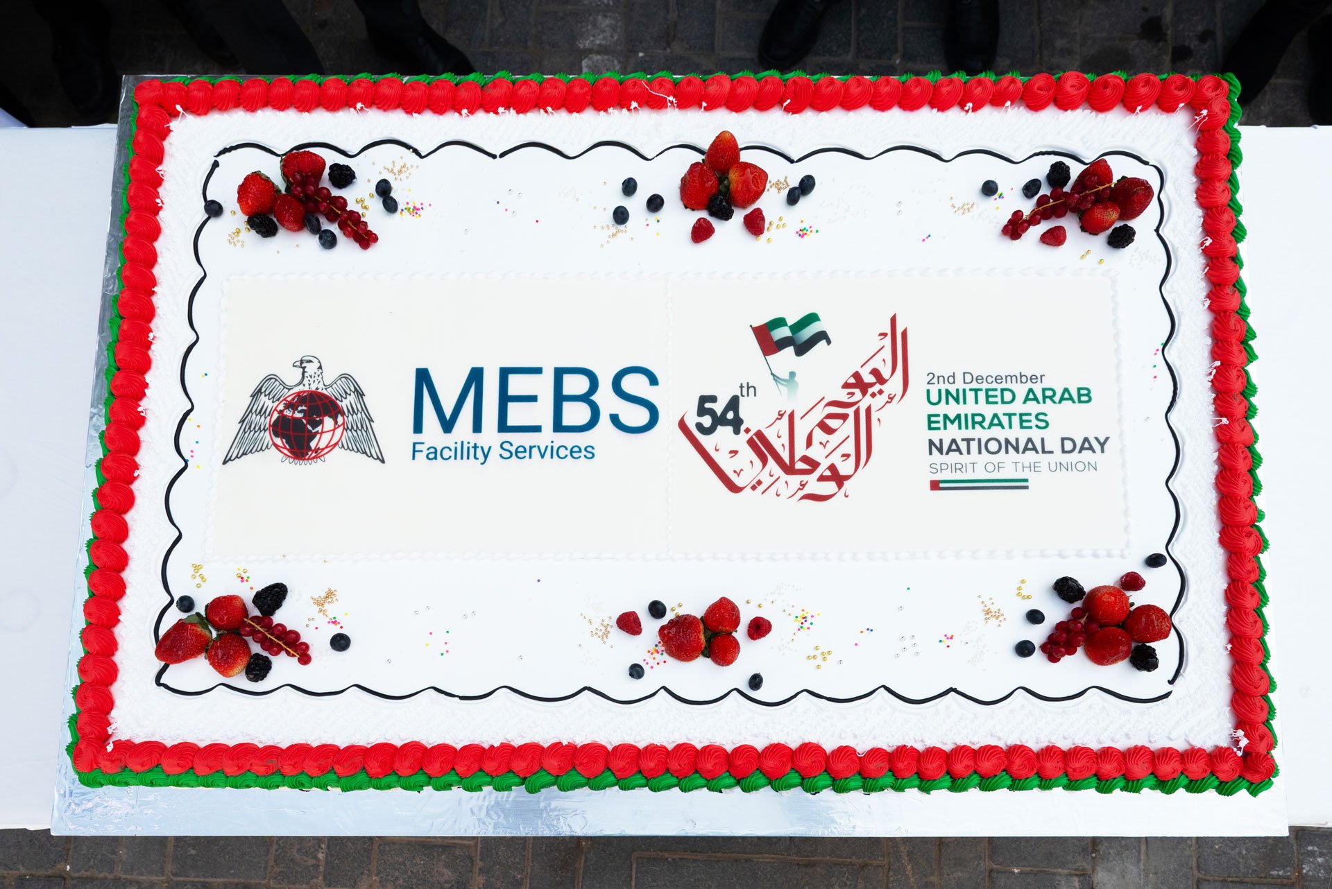 Team members participating in the UAE National Day cake-cutting ceremony at MEBS Facility Services