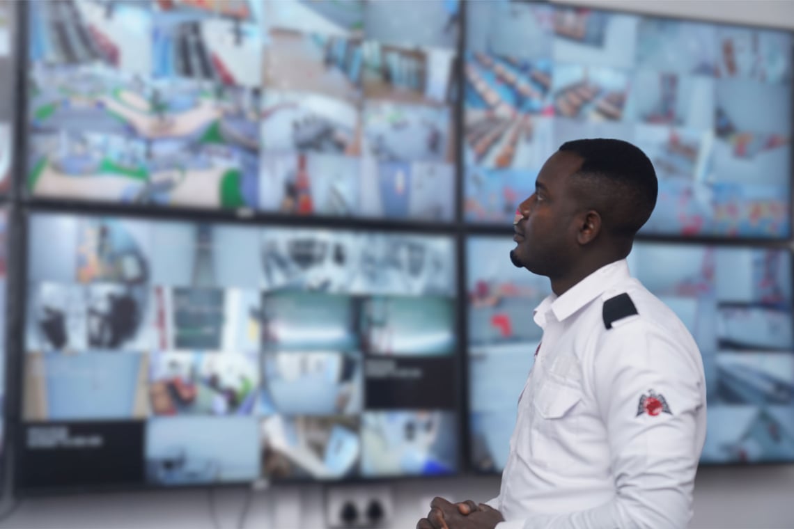 Security guard monitoring CCTV screens inside a Dubai facility